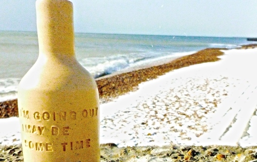 Graffiti bottle on Brighton beach by Anon.